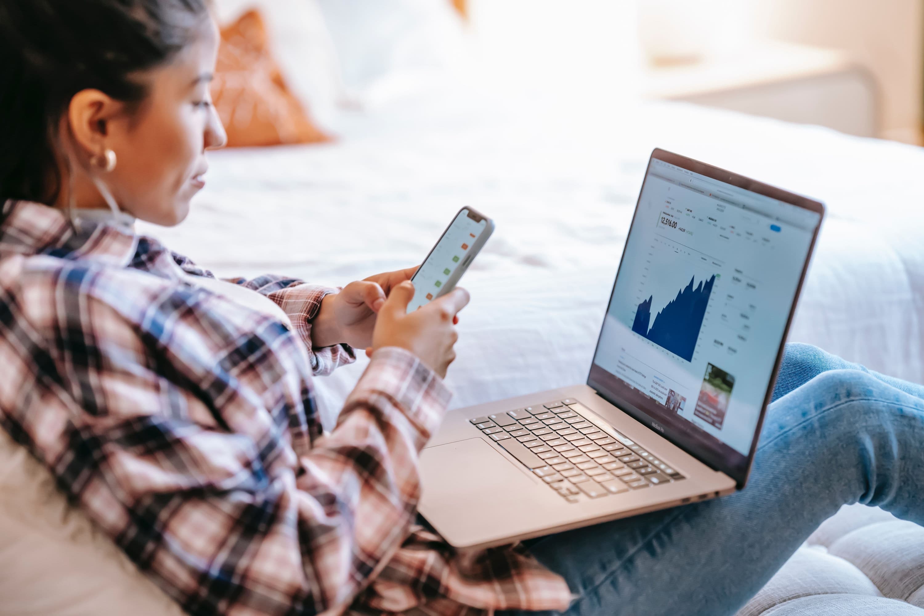 Eine Kundin sitzt am Laptop und möchte einen günstigen Kredit für ihr Haus finden. Sie nutzt einen Kreditvermittler und spart sich Zeit und Geld.